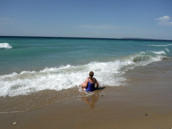 Karen Duquette sits on the shoreline of Lake Michigan